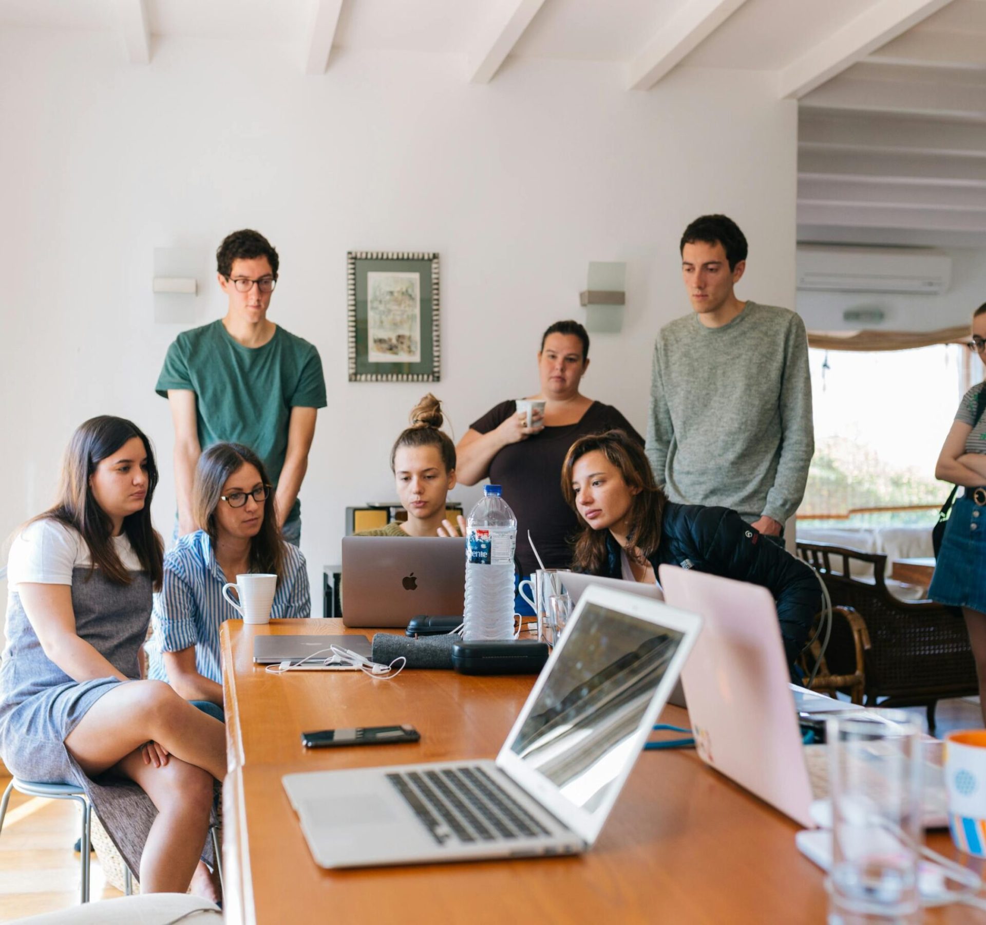 Group of young professionals engaged in a collaborative meeting in a modern office setting.